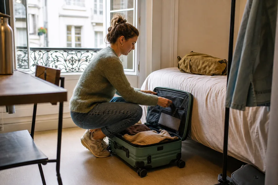 independent travelers comparing lightweight carry on luggage for a bag rolls through an airport, lifts onto a train, climbs apartment stairs, and opens in a small room.